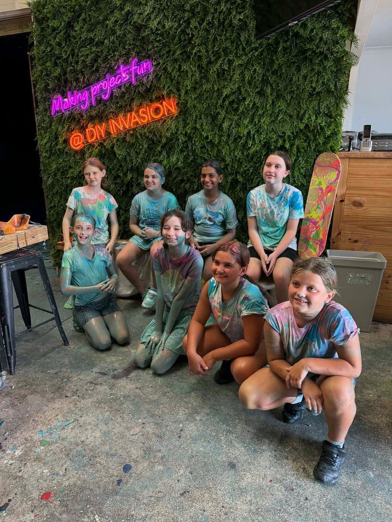 Group of children with paint-splattered faces posing in the party room